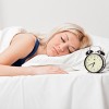 Woman Sleeping Next To Alarm Clock