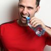 Man Opening Water Bottle with Teeth