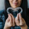 Patient Making a Heart Shape with Dental Aligners